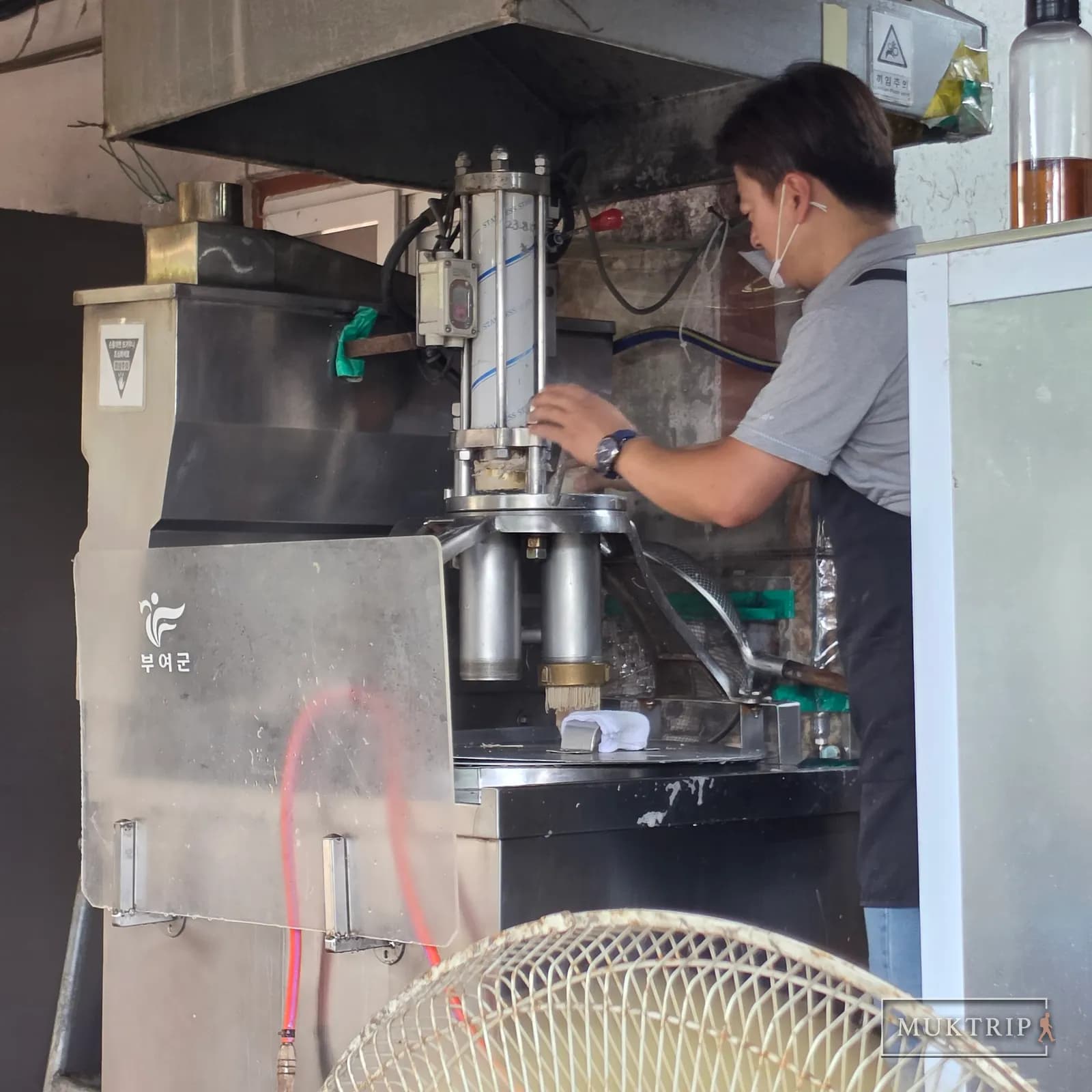 麺押し機でマッククスの麺を直接押し出す店主