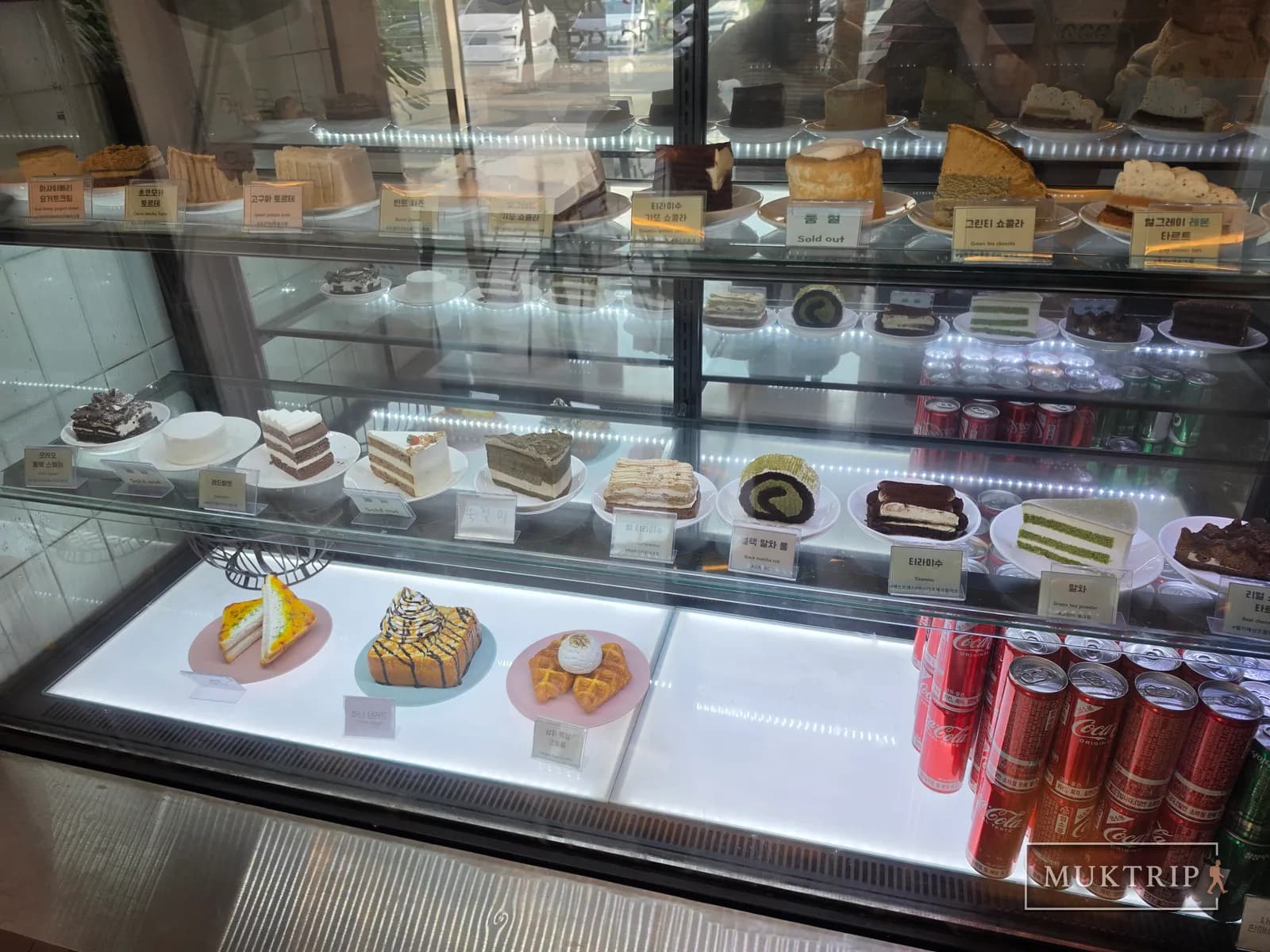 A display case lined with cakes and desserts