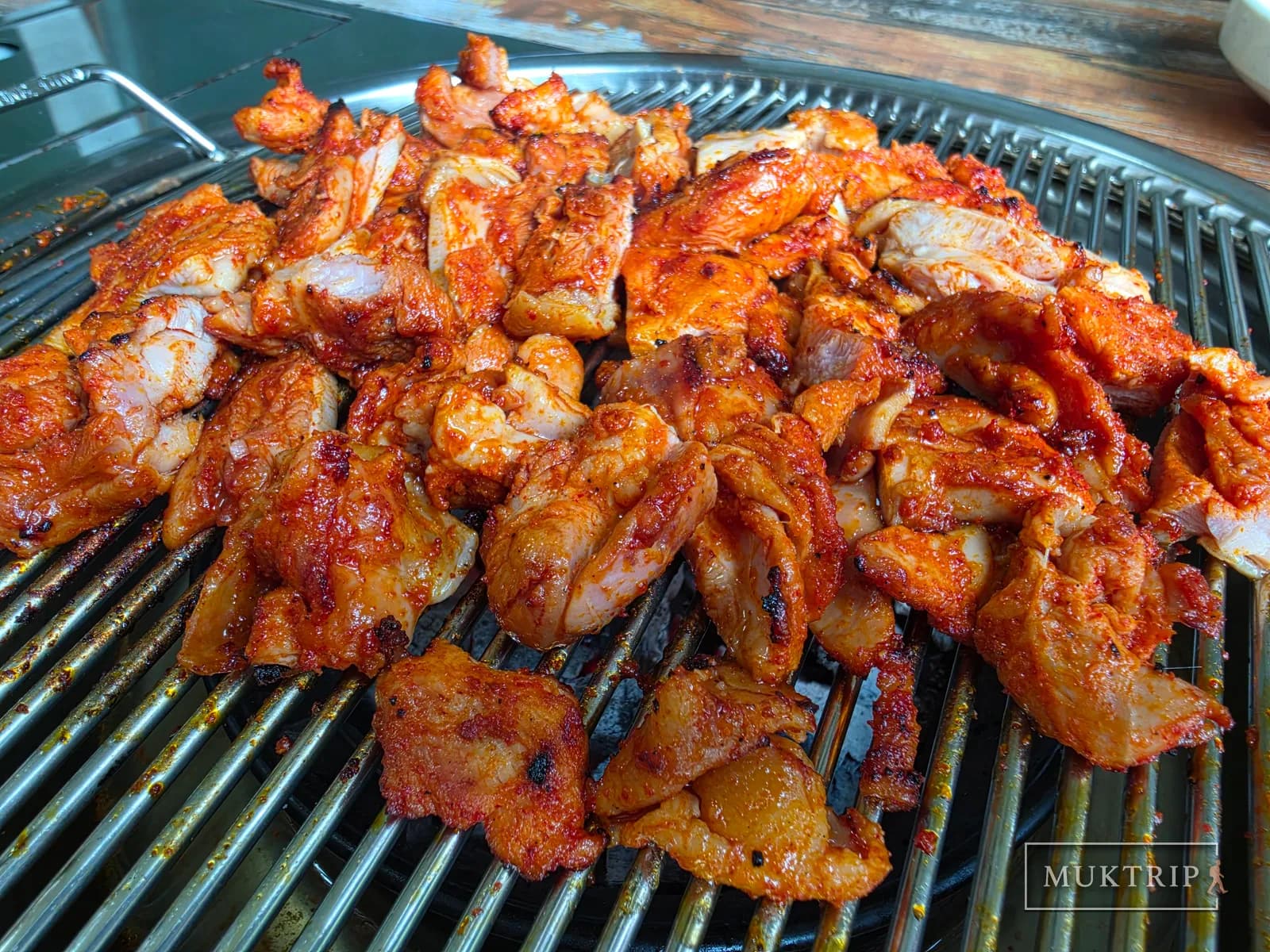 Seasoned dakgalbi on the charcoal grate