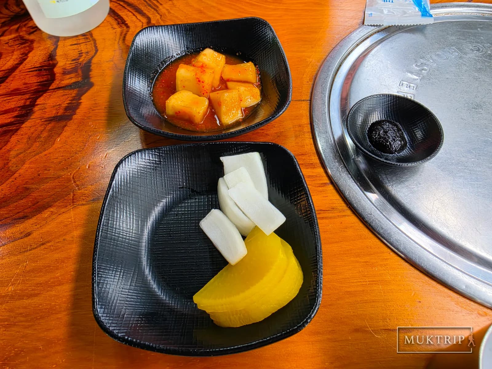 A side dish plate with seasoned kkakdugi, onion, and danmuji