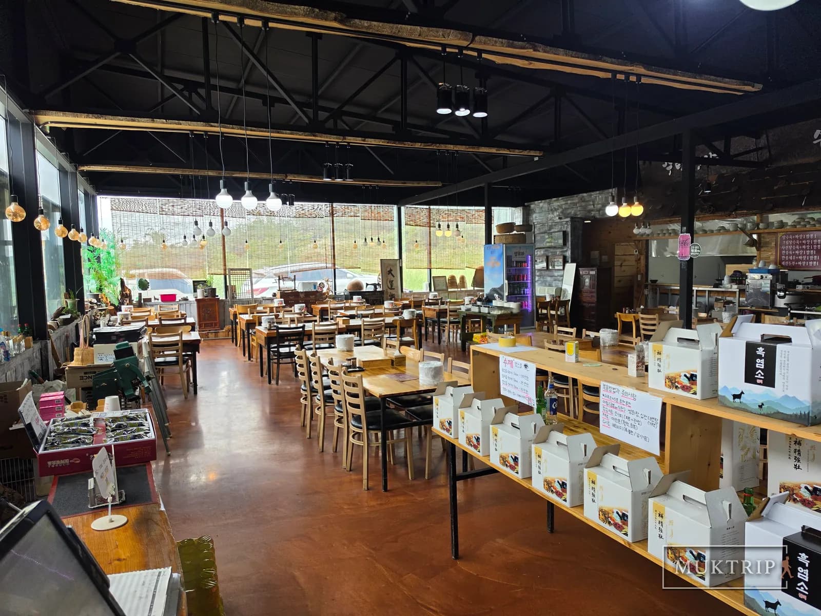 Spacious table seating and display shelves inside Sutamyeongga Jiheungseon Food Village (Hand-Pulled Noodle Restaurant)
