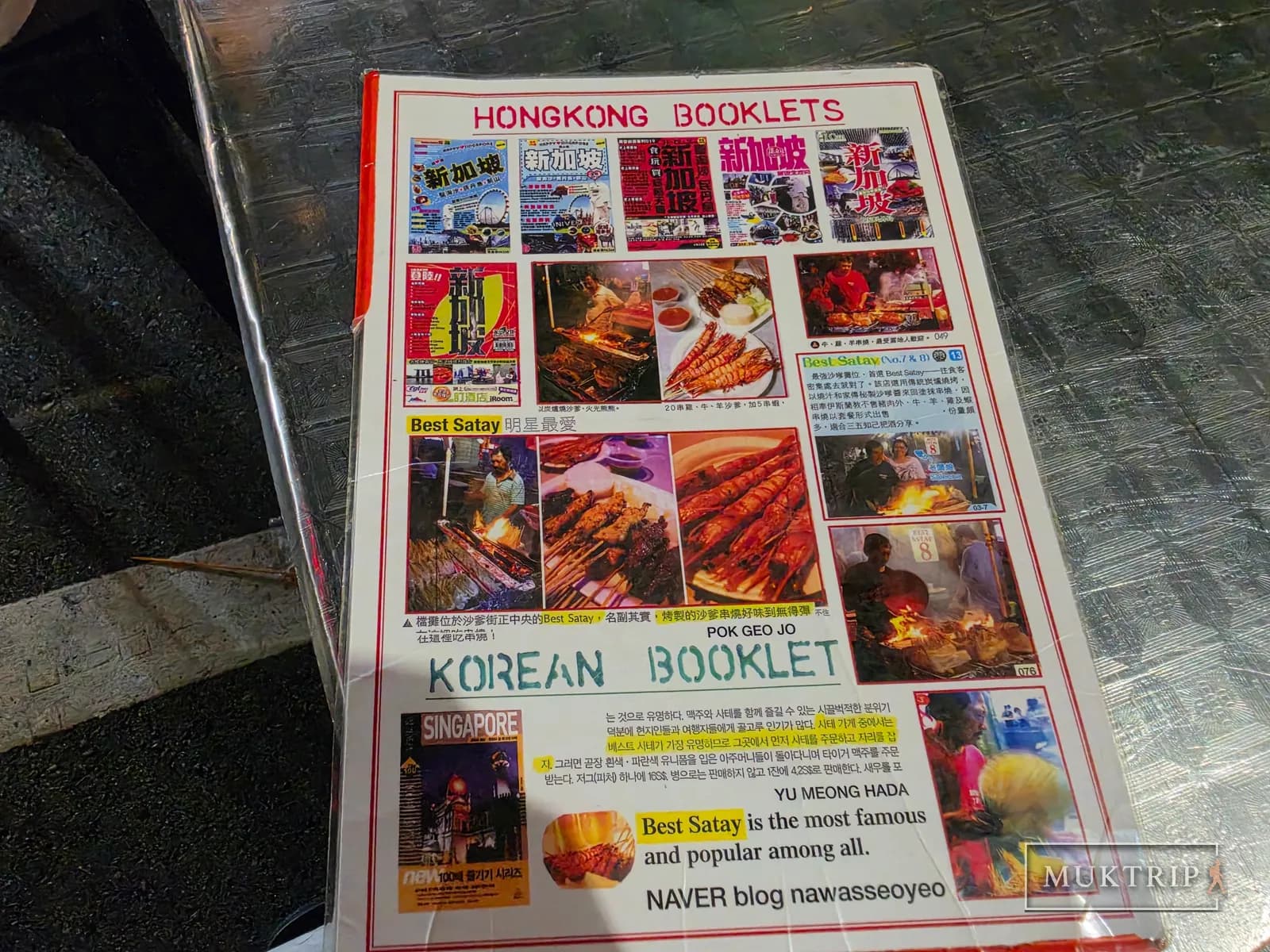 A collage board of press clippings from various countries' media posted at the Lau Pa Sat Best Satay stall
