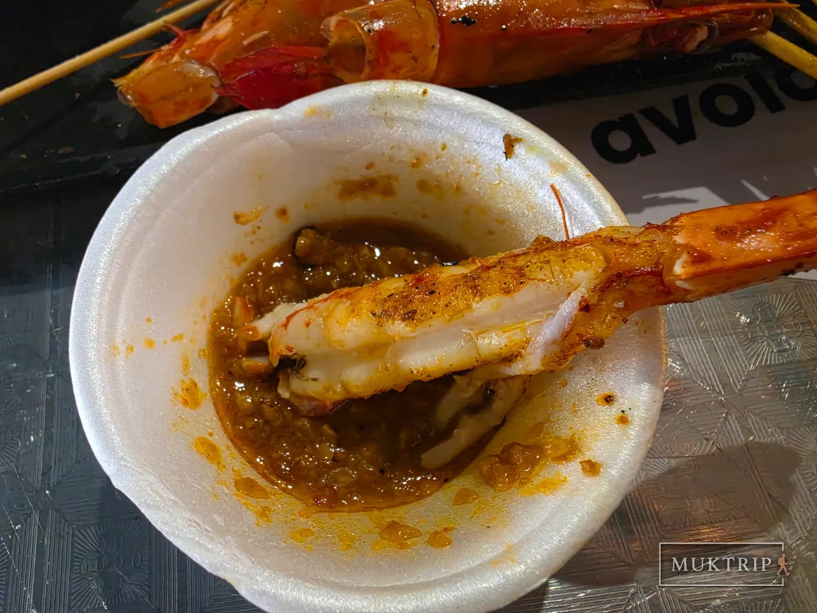 Dipping prawn meat into sauce