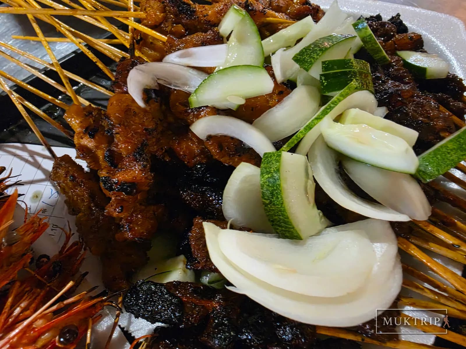 Close-up of chicken and lamb skewers topped with zucchini and onion