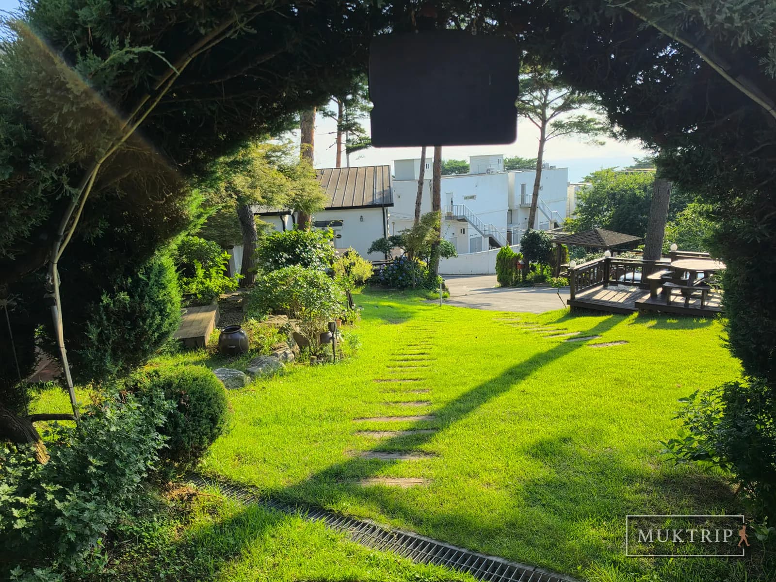 A stepping-stone path through the lawn leading between tree arches