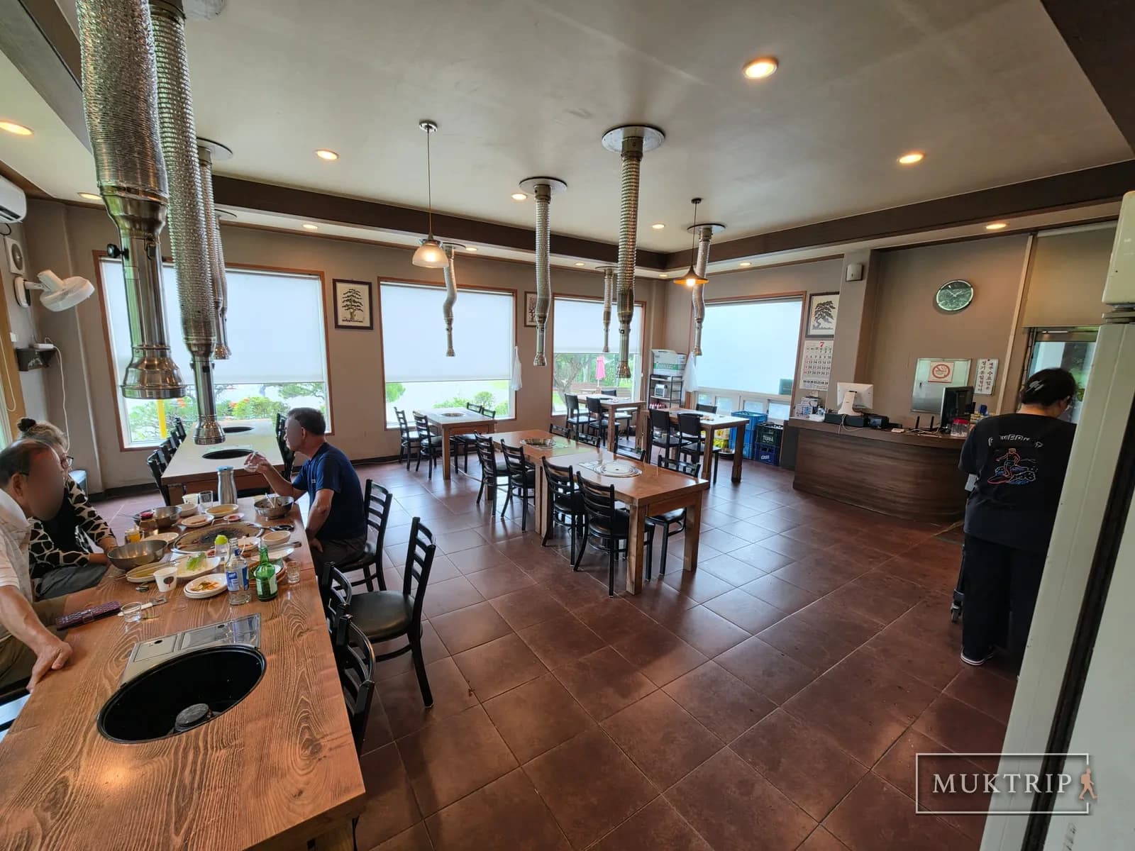 Interior view of the restaurant with charcoal grill tables and guests