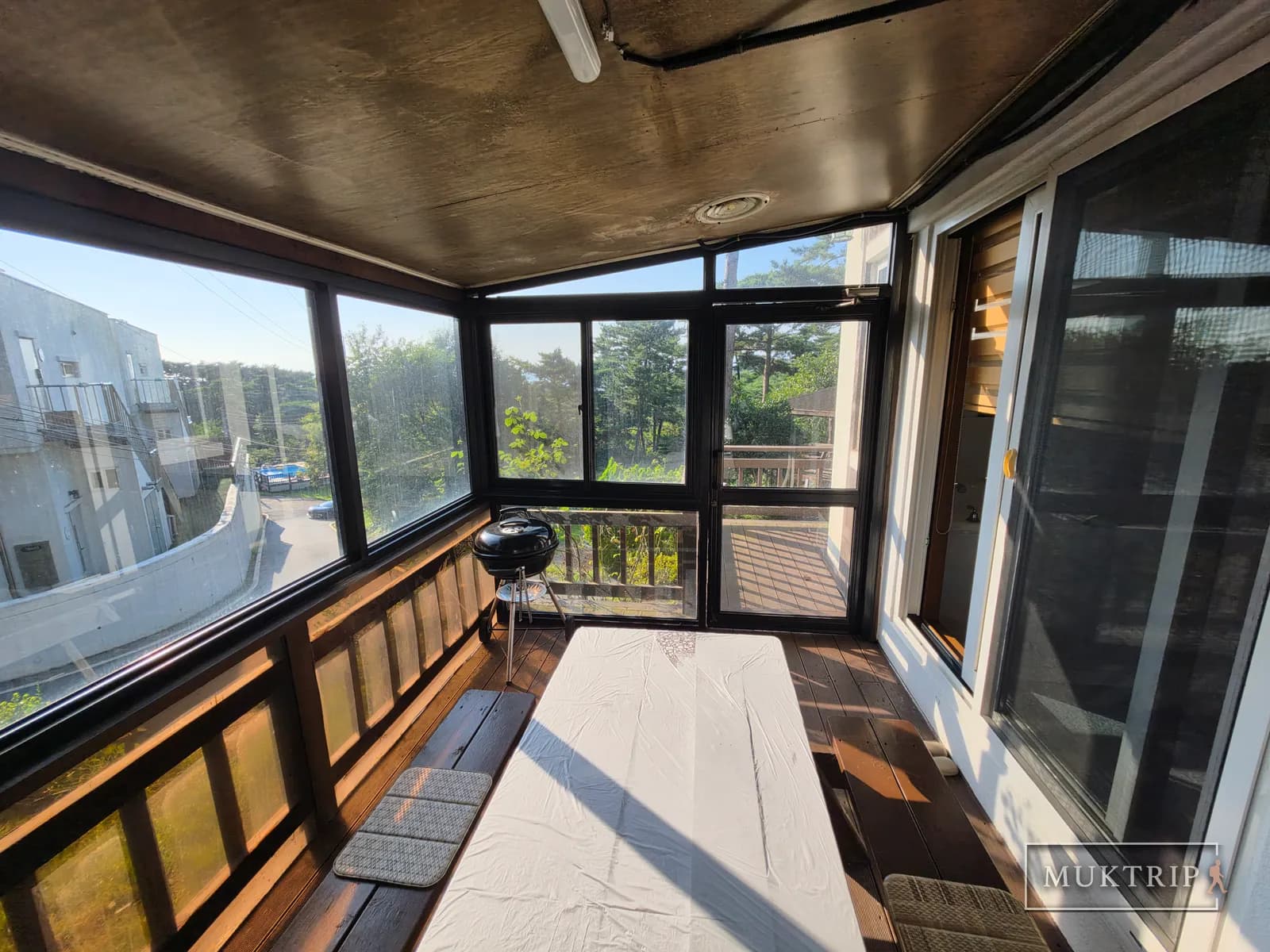 A dining table and mini grill placed in the sunroom of a Ssolmirabell Pension room