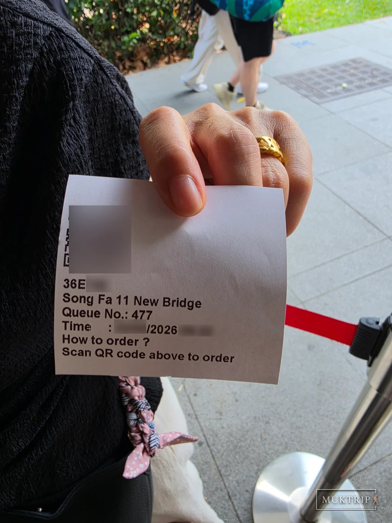 A Song Fa Bak Kut Teh queue ticket and QR code held in hand