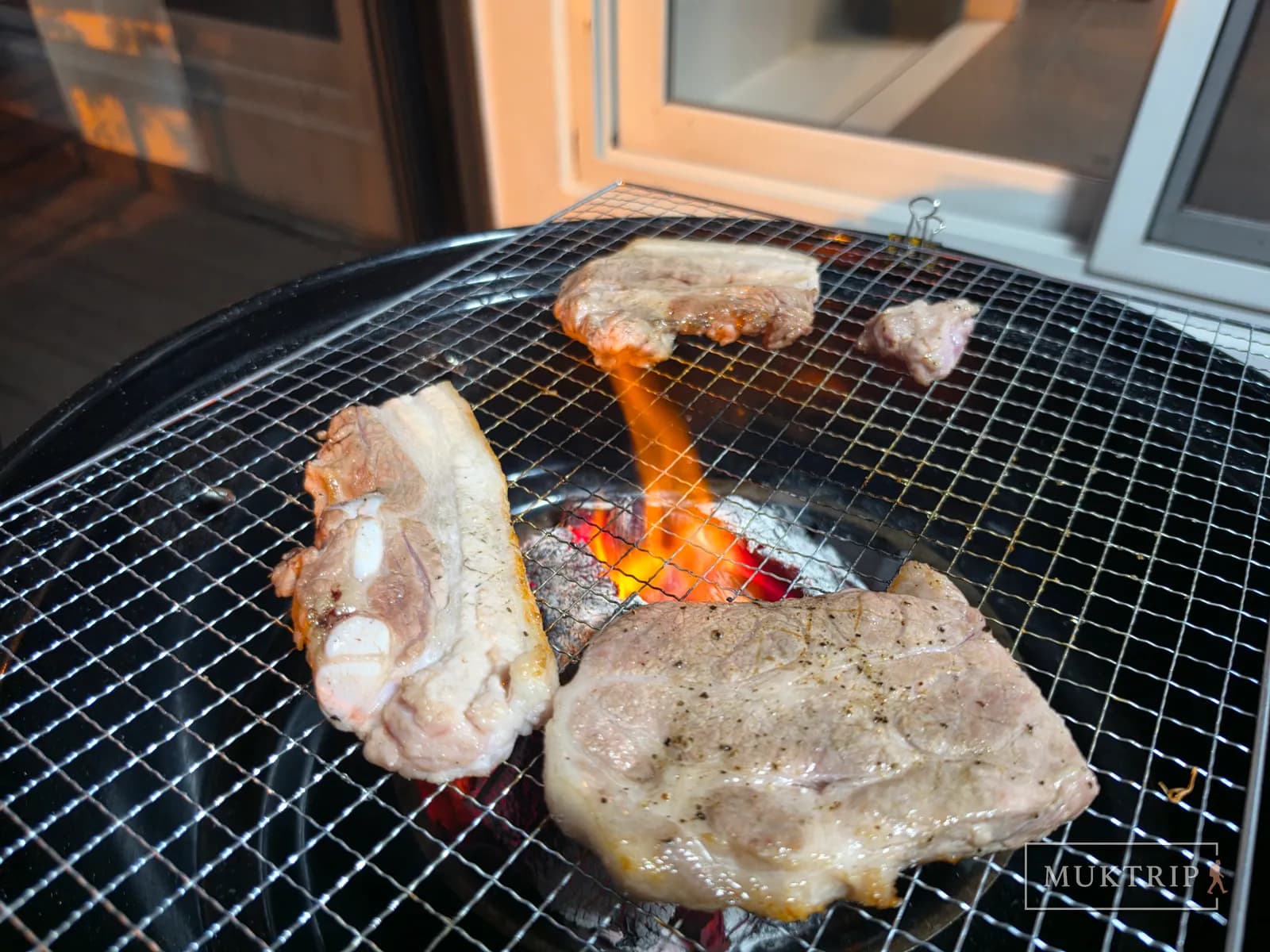 Grilling meat over a charcoal brazier on the terrace of Ssolmirabell Pension