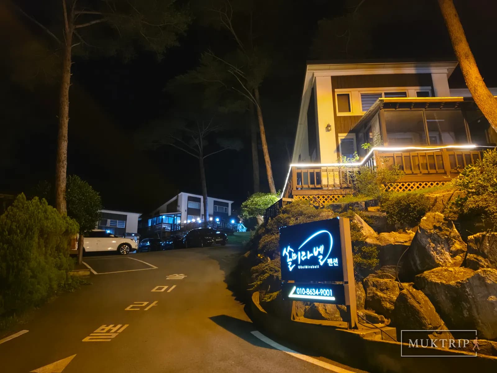 A night view of the Ssolmirabell Pension entrance sign and parking lot
