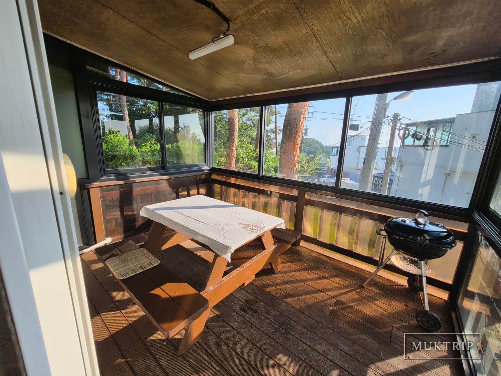 A table and barbecue grill placed on the full-glass terrace