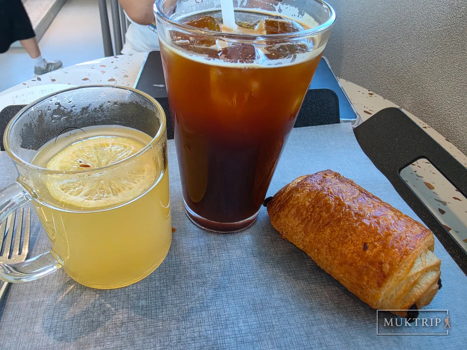 アイスアメリカーノと柚子茶、パンが置かれたカフェのテーブル