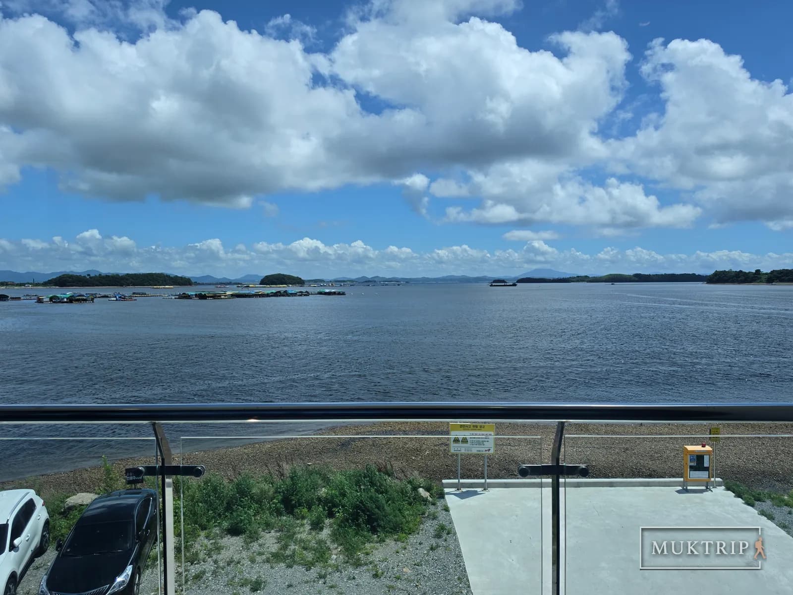 テラスの手すりの向こうに穏やかな海が広がる